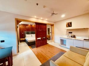 a living room with a couch and a bed at The Habitat Suites-Walkable distance to Guruvayoor temple in Guruvāyūr