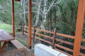 a porch with a wooden fence and a picnic table at Cabañas Valle del Río in Curacautín