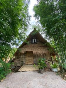 a hut with a window in the middle of trees at Royal mountain Hut in Ratchaburi