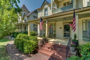 Carrier Houses Bed & Breakfast في Rutherfordton: منزل به علمان أمريكي على الشرفة