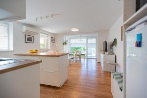 a kitchen with white cabinets and a hard wood floor at Apartment Alba with garden in Piran