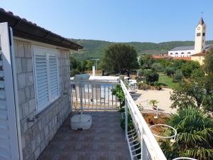 a balcony of a house with a view of a yard at Unterkunft Dalmatin in Dračevo