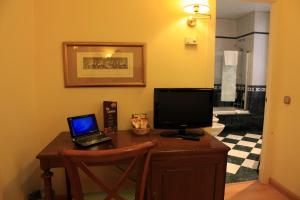 a desk with a laptop and a computer monitor at Hotel Cervantes in Seville