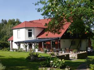 una casa bianca con il tetto rosso di Dworek dla alergikow "U Szkota" a Jelenia Góra