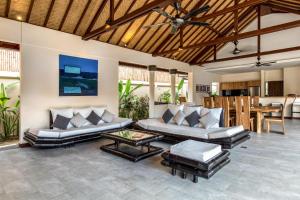 a living room with two couches and a table at Villa Lotus in Nusa Lembongan