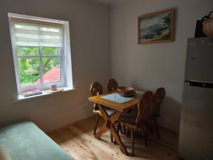 a kitchen with a table and chairs and a window at Poilsis Juodkrantėje in Juodkrantė