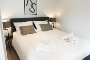 a bedroom with a white bed with towels on it at Child-friendly With Equipped Kitchen, Gerard in Eindhoven