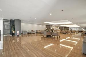 a lobby with chairs and tables in a building at Makati 1BR with Skyline View at Air Residences in Manila