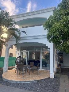 Apartment in villa with sea view في Calodyne: فناء مع كراسي وطاولة أمام المنزل