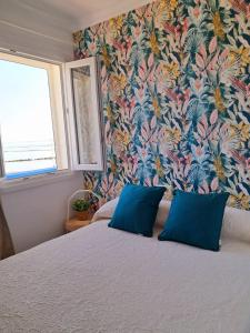 a bedroom with a bed with a floral wallpaper at Casa mirando al mar, hermosas vistas. in Chipiona