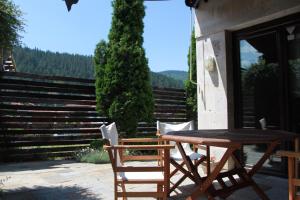 einen Holztisch und Stühle auf einer Terrasse mit Treppen in der Unterkunft The Stone Villa in Beli Iskar