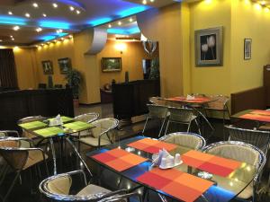 un ristorante con tavoli e sedie in una stanza di Hotel Condori a Kobuleti