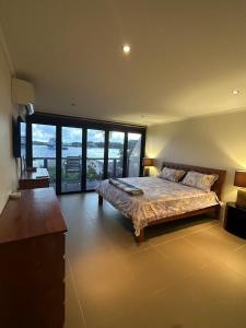 a bedroom with a large bed and a large window at Blue Marlin Lodge in Port Vila