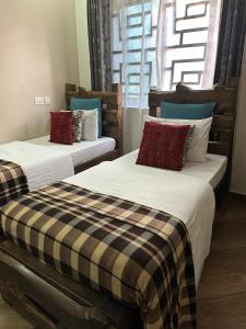 two beds sitting next to each other in a room at MINA CHAI HOUSE BNB in Arusha