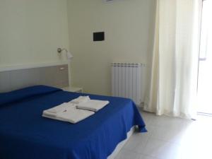フォルミアにあるb&b Il Girasole Formia Guesthouseのベッドルーム1室(ブルーベッド1台、タオル2枚付)