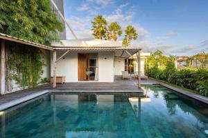 a villa with a swimming pool and a house at Villa Rice - Amazing Rice-Field VIEW 3BR Villa 9px Next To Canggu in Kerobokan