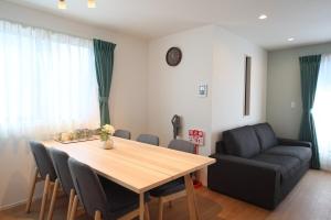 a dining room with a table and a couch at Fukuoka Airport 3 in Fukuoka