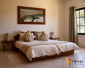 a bedroom with a large bed with white sheets and pillows at Okajo Safari Lodge in Wilhelmstal +38 photos