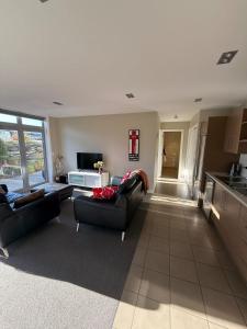 a living room with two couches and a kitchen at Queenstown Alpine Escape in Frankton
