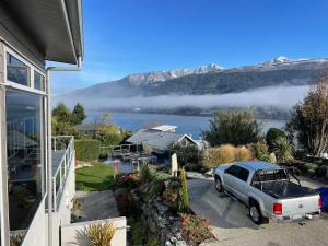 a car parked in a driveway next to a house at Queenstown Alpine Escape in Frankton +11 photos