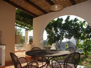 a table and chairs on a patio with an archway at Villa Hermes Case Vacanza in Lipari +69 photos