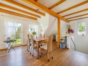 a dining room with a wooden table and chairs at Ruegenbrise-mit-Seeblick-Fewo-OG in Zudar +20 photos