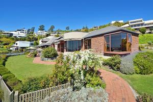 a house with a garden and a fence at The Cliffs - Nelson Waterfront Home in Nelson