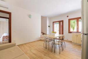 eine Küche und ein Esszimmer mit Tisch und Stühlen in der Unterkunft Corte di Gallura in Budoni + 52 Fotos
