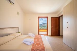 a bedroom with a bed with two towels on it at Corte di Gallura in Budoni