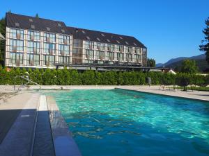 a large swimming pool in front of a large building at Lyra Hotel Plitvice in Ličko Petrovo Selo
