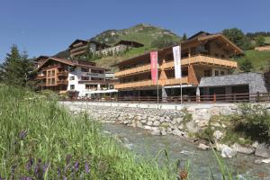 un gruppo di edifici vicino a un fiume di Hotel Auenhof a Lech am Arlberg