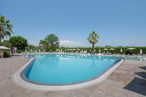 a large swimming pool with chairs and umbrellas at Ca' dei Vigneti in Colà di Lazise