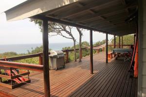 a wooden deck with a picnic table and a grill at Vila do Monte, Villa #8, Ponta Mamoli in Ponta Mamoli +22 photos