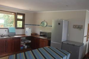 a kitchen with a white refrigerator and a sink at Vila do Monte, Villa #8, Ponta Mamoli in Ponta Mamoli