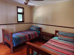 a room with two beds and a window at Vila do Monte, Villa #8, Ponta Mamoli in Ponta Mamoli
