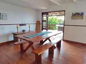 a dining room with a wooden table and a refrigerator at Vila do Monte, Villa #8, Ponta Mamoli in Ponta Mamoli