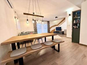 ein Esszimmer mit einem Holztisch und Bänken in der Unterkunft Ágica Nyaraló in Balatonkenese