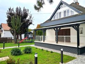 ein Haus mit einem Pavillon und einem Spielplatz in der Unterkunft Ágica Nyaraló in Balatonkenese