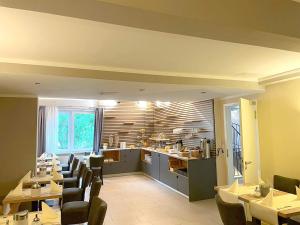 a restaurant with tables and chairs and a kitchen at Hotel Jeta in Hamburg