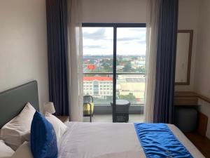 a hotel room with a bed and a large window at Republic Plaza - View sân bay, view hồ bơi in Ho Chi Minh City +9 photos