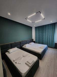una habitación con dos camas en una habitación en Aura Hotel, en Durrës