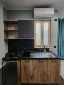 una cocina con fregadero y ventana en Aura Hotel, en Durrës