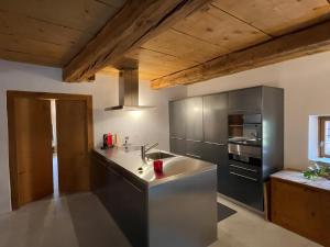 a kitchen with a sink and a stove at Historisches Teiler-Haus in Splügen
