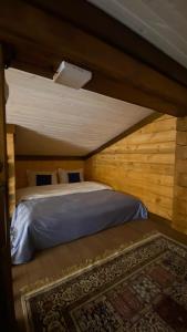 a bedroom with a bed in a wooden room at Риддер Тайга- Ridder Taiga 