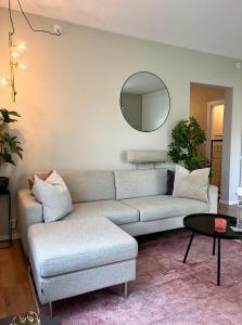 a living room with a couch and a mirror at Modern apartment with a balcony and free parking in Oslo