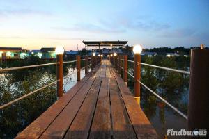 a wooden bridge over water with lights on it at Sea Lion Pulau Ketam Bungalow Homestay in Bagan Teochew +13 photos