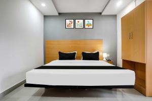 Un dormitorio con una gran cama blanca con dos almohadas. en Collection O Shamshabad Near Airport, en Shamshabad