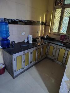 a kitchen with a sink and a counter in a room at श्री राधा होम स्टे in Chhatikara