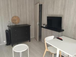 a living room with a tv and a table and chairs at F1 meublé indépendant in Chambray-lès-Tours