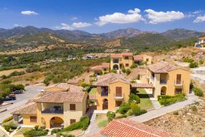 arial view of a house with mountains in the background at Corte di Gallura in Budoni